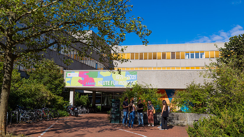 Image: A small group of students stands in front of the entrance to the AVZ.