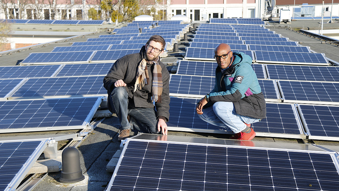 Christian Hachmann and Manuel Valois in the middle of a photovoltaic system