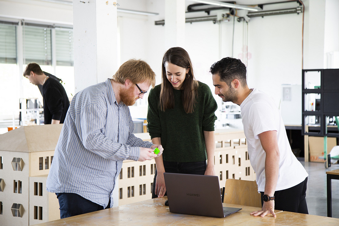 Teaching and working situation in the studio with three people in the foreground