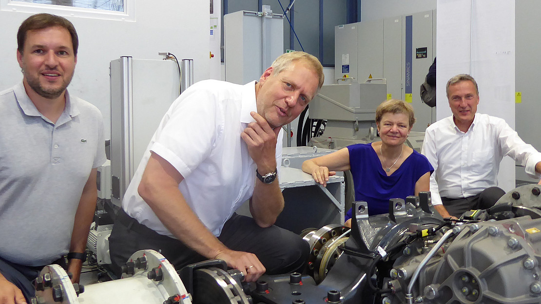 Das Foton zeigt Am neuen Großprüfstand (v.li): Henning Rimbach (Leiter Kompetenzzentrum E-Achse Daimler Truck Werk Kassel), Prof. Dr.-Ing. Michael Fister (FG Mechatronik mit dem Schwerpunkt Fahrzeuge), Universitätspräsidentin Prof. Dr. Ute Clement, Prof. Dr. Frank H. Lehmann (Standortverantwortlicher des Mercedes-Benz Werks Kassel).