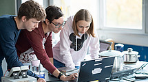 Three young people at the computer.