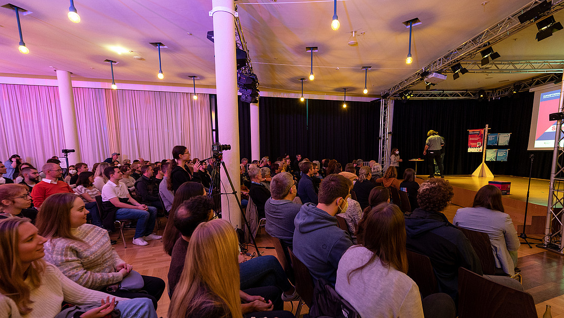 The photo shows a university event in the opera foyer in Kassel